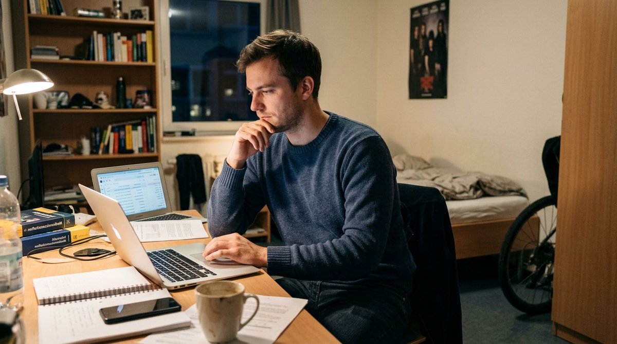 Mann im Wohnheim informiert sich am Notebook &uuml;ber Wahlumfragen